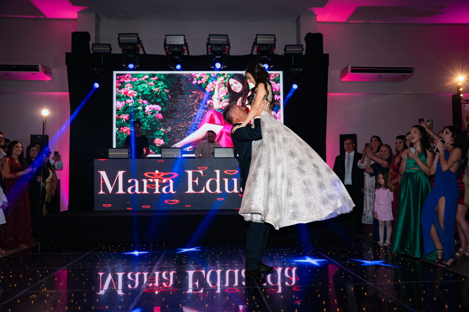 Debutante dançando no palco com o nome no telão